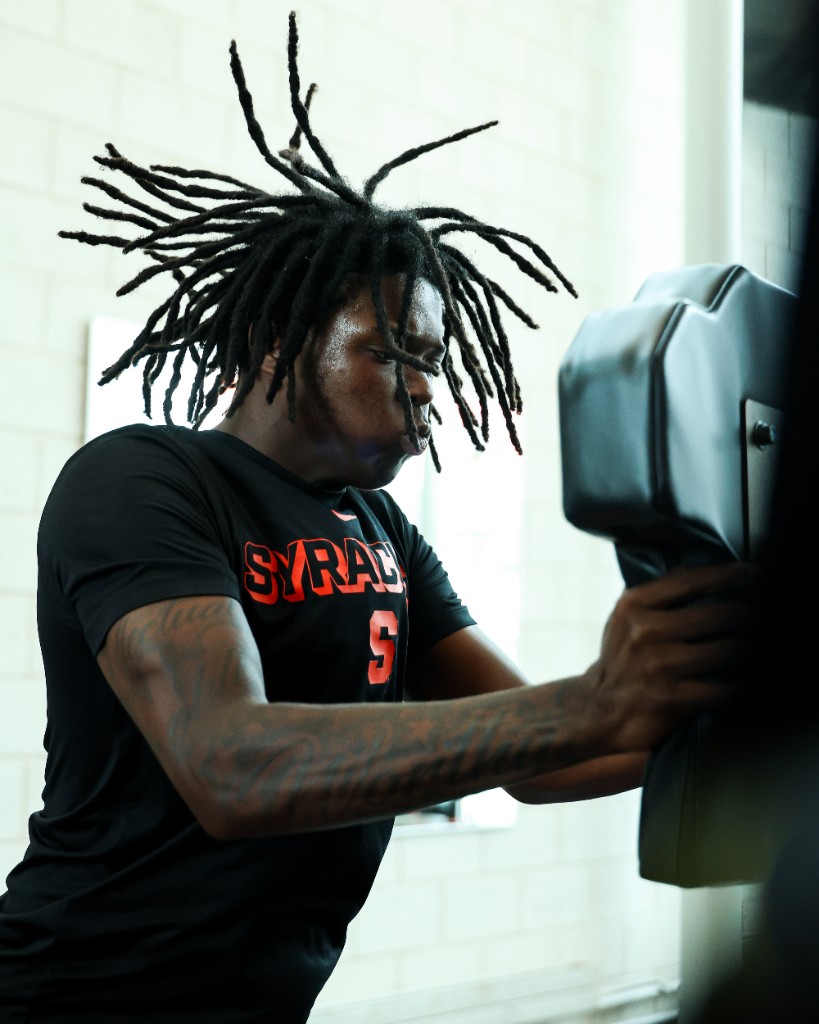 BJ Garrett hitting a blocking pad in a Syracuse training shirt